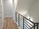 Bright hallway with hardwood floors, white walls, black iron railing, modern fixtures, and a clean aesthetic at 327 Coxe Ave, Charlotte, NC 28208