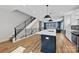 Open-concept kitchen with modern island, stainless steel appliances, and an open staircase at 327 Coxe Ave, Charlotte, NC 28208