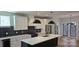 Modern kitchen featuring white cabinetry, stainless steel appliances, black island with a sink, and tile backsplash at 327 Coxe Ave, Charlotte, NC 28208