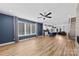 An open-concept living room with hardwood floors, a ceiling fan, and a large window with natural light at 327 Coxe Ave, Charlotte, NC 28208