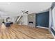 Open-concept living room featuring a stone fireplace, modern ceiling fan, and wood flooring at 327 Coxe Ave, Charlotte, NC 28208