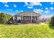 Spacious backyard patio with outdoor kitchen, hot tub, dining, and grill areas, framed by lush landscaping at 423 Granite Lake Ct, Denver, NC 28037