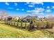 Picture of a lovely backyard with a patio, neatly trimmed bushes, and a black fence under a bright cloudy sky at 423 Granite Lake Ct, Denver, NC 28037