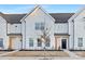 Up close new construction townhome with a black front door, light-colored wood beams, and a landscaped front yard at 444 Berryman Rd, Rock Hill, SC 29732