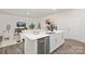 A modern kitchen featuring an island with a sink and stainless steel appliances opens up to the bright living room at 444 Berryman Rd, Rock Hill, SC 29732