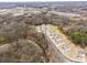 Aerial view of the house nestled in a wooded neighborhood with a nearby river and downtown area at 4551 Selhurst Dr, Indian Land, SC 29707