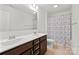 Bathroom features a double sink vanity with dark wood cabinets and a shower with patterned curtains at 4551 Selhurst Dr, Indian Land, SC 29707