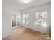 Bright bedroom featuring natural light, neutral carpet, a glass paneled door, and decorative curtains at 4551 Selhurst Dr, Indian Land, SC 29707