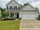 Charming two-story home features a well-manicured lawn, a two-car garage, and a welcoming front porch at 4551 Selhurst Dr, Indian Land, SC 29707