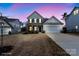 Charming two-story home featuring a well-manicured lawn, black shutters, and an attached two-car garage at dusk at 4551 Selhurst Dr, Indian Land, SC 29707