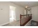 Upstairs hallway with carpeted floor and wooden railing at 1021 Kings Mountain Ln, Gastonia, NC 28054