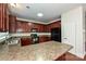 Kitchen with dark wood cabinets, granite countertops, and black appliances at 1021 Kings Mountain Ln, Gastonia, NC 28054