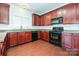 Kitchen with dark wood cabinets, granite countertops, and black appliances at 1021 Kings Mountain Ln, Gastonia, NC 28054