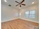 Light-filled bedroom with hardwood floors, a ceiling fan, and a door leading outside at 15334 S Birkdale Commons Pkwy, Huntersville, NC 28078