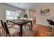 Bright dining room features a dark wood table with white chairs and a neutral rug at 15334 S Birkdale Commons Pkwy, Huntersville, NC 28078