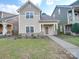 Tan two-story house with gray trim, a walkway, and a well-maintained lawn at 15334 S Birkdale Commons Pkwy, Huntersville, NC 28078