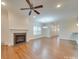 Spacious living room with hardwood floors, a fireplace, and a ceiling fan at 15334 S Birkdale Commons Pkwy, Huntersville, NC 28078