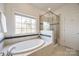 Bathroom with soaking tub, walk-in shower, and a large window at 5110 Pansley Dr, Charlotte, NC 28226