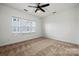 Bright bedroom with a ceiling fan, three windows providing natural light, and patterned carpet at 547 Old Mill Rd, Charlotte, NC 28206