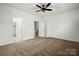 Neutral bedroom with a ceiling fan, neutral carpet, white walls and trim, and multiple doors at 547 Old Mill Rd, Charlotte, NC 28206