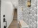 Hallway with decorative wallpaper, bench seating, and hardwood floors at 547 Old Mill Rd, Charlotte, NC 28206