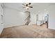 Spacious living room featuring neutral carpeting, a ceiling fan, and an open layout to the kitchen at 547 Old Mill Rd, Charlotte, NC 28206