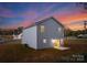 Rear view of two-story house at dusk; lights on inside at 7420 Gwynne Cir, Charlotte, NC 28214