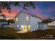 Rear view of two-story house at dusk; lights on inside at 7420 Gwynne Cir, Charlotte, NC 28214