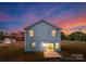 Rear view of two-story house at dusk; lights on inside at 7420 Gwynne Cir, Charlotte, NC 28214