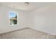 Simple bedroom with gray carpeting and a large window at 8508 Sunflower Rd, Charlotte, NC 28227