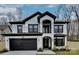 Beautiful two-story home with a black-and-white painted brick exterior, dark trim, and a two-car garage at 1308 Pleasant Plains Rd, Matthews, NC 28105