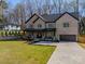 Beautiful brick home showcasing a well-manicured lawn and a long driveway leading to a two-car garage at 1312 Pleasant Plains Rd, Matthews, NC 28105