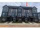 Modern townhome complex featuring gray siding, black brick accents, and large windows, showcasing contemporary design at 1312 Walter Taylor Way # Eqx0104, Charlotte, NC 28206