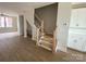 Inviting entryway features staircase with wood trim, light vinyl flooring, and views of the living area and kitchen at 1316 Walter Taylor Way # Eqx0103, Charlotte, NC 28206