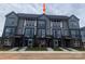 Modern townhome showcases gray siding, black brick accents, and a well-maintained lawn at 1316 Walter Taylor Way # Eqx0103, Charlotte, NC 28206