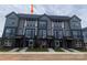 Modern townhome exterior features gray siding, brick accents, and a well-manicured lawn at 1320 Walter Taylor Way # Eqx0102, Charlotte, NC 28206
