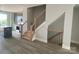 Open-concept living space featuring modern gray flooring, a staircase, and a glimpse into the kitchen with stainless steel appliances at 1320 Walter Taylor Way # Eqx0102, Charlotte, NC 28206