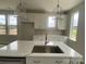 Bright kitchen features a spacious island with a stainless steel sink, white cabinets, and pendant lighting at 1324 Walter Taylor Way # Eqx0101, Charlotte, NC 28206