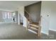 Open living room with light vinyl flooring and a staircase that has wood treads and a black iron railing at 1324 Walter Taylor Way # Eqx0101, Charlotte, NC 28206