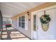 Covered front porch with white door, wreath, and ample light, offering a cozy and inviting entrance to the home at 150 Windmill Ct, Harmony, NC 28634