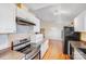 Bright kitchen featuring white cabinets, stainless steel appliances and wood look floors at 150 Windmill Ct, Harmony, NC 28634