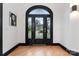 Elegant entryway with arched doorway, hardwood floors, and stained glass at 18805 Flat Shoals Dr, Cornelius, NC 28031