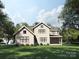 Two-story home with a lush green lawn, large windows, screened in porch, and mature trees on a sunny day at 3814 Topsfield Rd, Charlotte, NC 28211