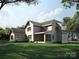 This two-story home has an enclosed sunroom, lovely green lawn, a fenced yard, and mature trees at 3814 Topsfield Rd, Charlotte, NC 28211