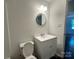 Bathroom with a white vanity, round mirror and neutral walls at 515 37Th Sw St, Hickory, NC 28602