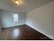 This bedroom offers wood-look floors, a window letting in natural light, and neutral walls at 515 37Th Sw St, Hickory, NC 28602