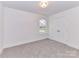 Bright bedroom features neutral carpet, white trim, a double closet, and a window with natural light at 5613 Morgan Mill Rd, Monroe, NC 28110