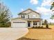 Charming two-story home boasts a blue front door, a spacious two-car garage, and a well-manicured front yard at 5613 Morgan Mill Rd, Monroe, NC 28110