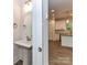 Cozy powder room featuring a pedestal sink with a stylish mirror and modern fixtures next to the kitchen at 5613 Morgan Mill Rd, Monroe, NC 28110