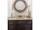 Small bathroom with round mirror, single vanity and dark brown cabinets at 117 Fairfield Dr, Troutman, NC 28166